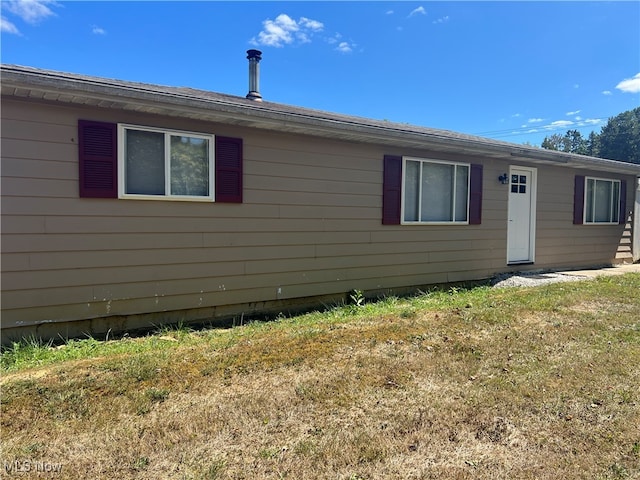 rear view of property featuring a lawn