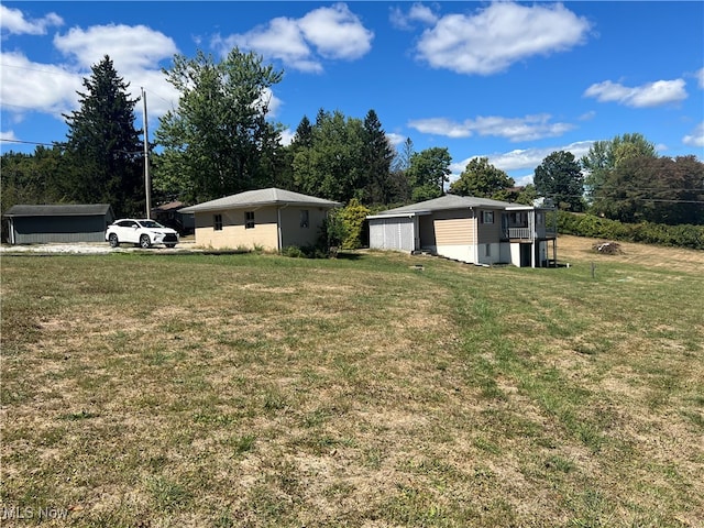 view of yard featuring a garage and an outbuilding