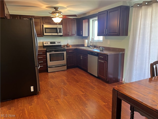 kitchen featuring appliances with stainless steel finishes, ceiling fan, dark hardwood / wood-style flooring, and sink