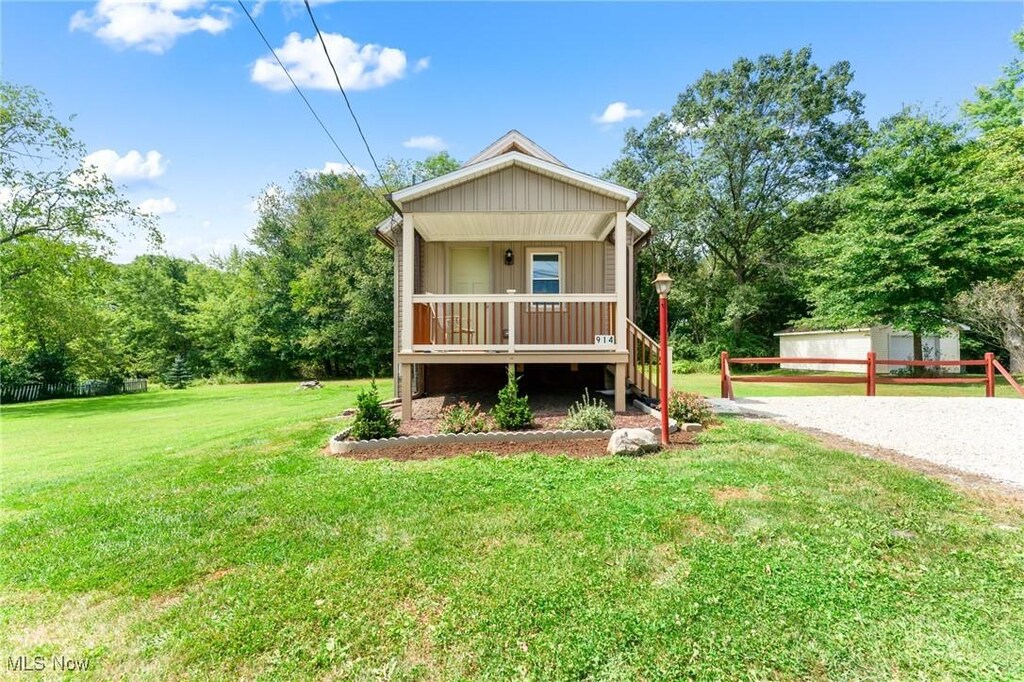914 Woodland Ave, Hubbard, OH 44425 - view of front facade featuring a front lawn, a garage, covered porch, and an outdoor structure