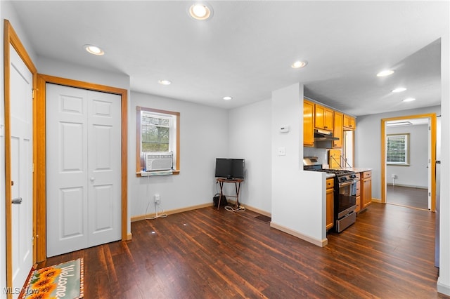 kitchen with dark wood-type flooring, stainless steel range with gas stovetop, and cooling unit