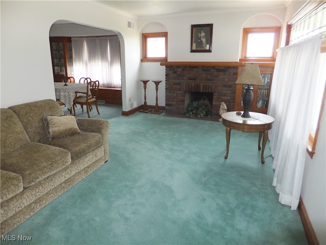 living room featuring carpet floors, a fireplace, and crown molding