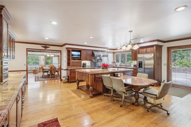 dining room with an inviting chandelier, crown molding, a wealth of natural light, and light wood-type flooring