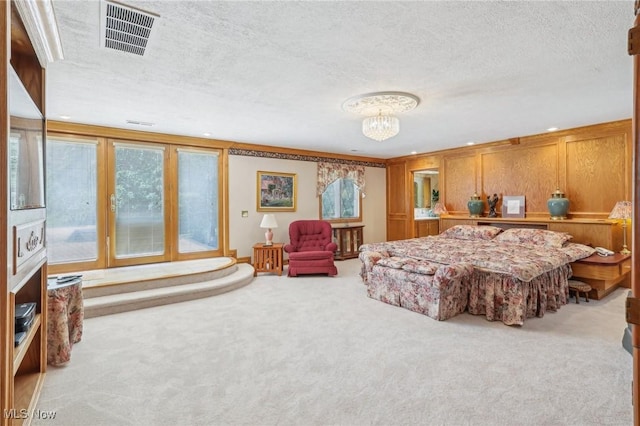 bedroom featuring a notable chandelier, ornamental molding, light colored carpet, and a textured ceiling