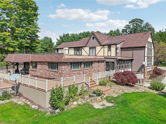 rear view of property with a lawn and a deck