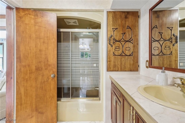 bathroom featuring enclosed tub / shower combo and vanity