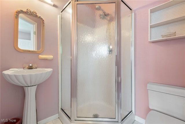 bathroom featuring tile patterned floors, toilet, and an enclosed shower