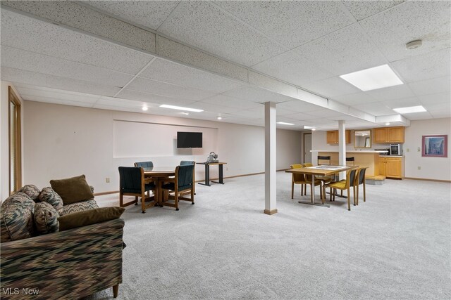 living room with a drop ceiling and light carpet