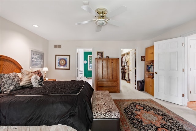 carpeted bedroom with a walk in closet, ceiling fan, a closet, and ensuite bathroom