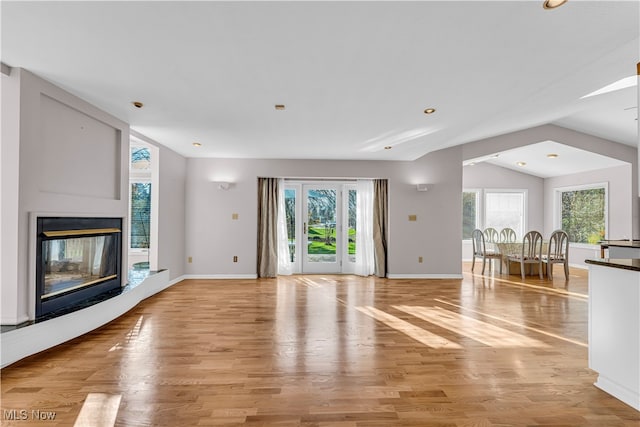 unfurnished living room with light hardwood / wood-style flooring and lofted ceiling