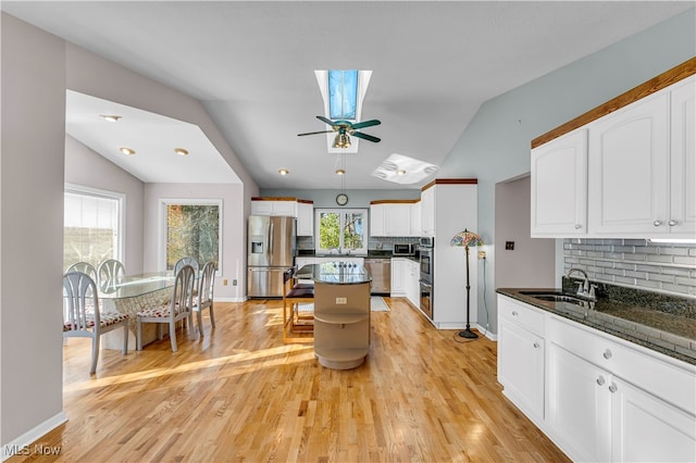 kitchen featuring white cabinets, stainless steel appliances, light hardwood / wood-style flooring, and sink