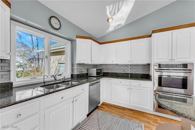 kitchen featuring white cabinets, lofted ceiling, and appliances with stainless steel finishes