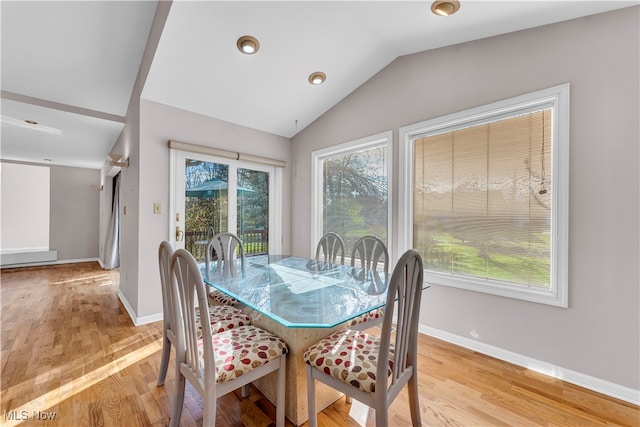 dining area with vaulted ceiling and light hardwood / wood-style flooring