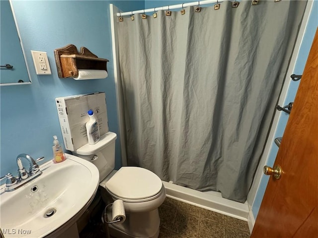 bathroom with a sink, toilet, and a shower stall