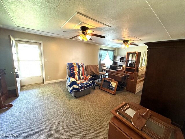 interior space with a textured ceiling, carpet, and ceiling fan