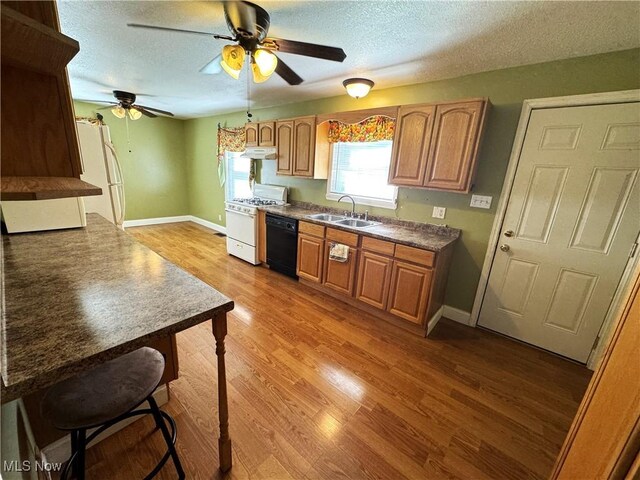 kitchen with white appliances, a textured ceiling, wood-type flooring, sink, and ceiling fan