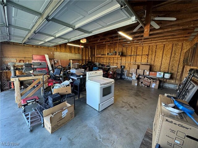 garage featuring washer / clothes dryer, ceiling fan, and wooden walls