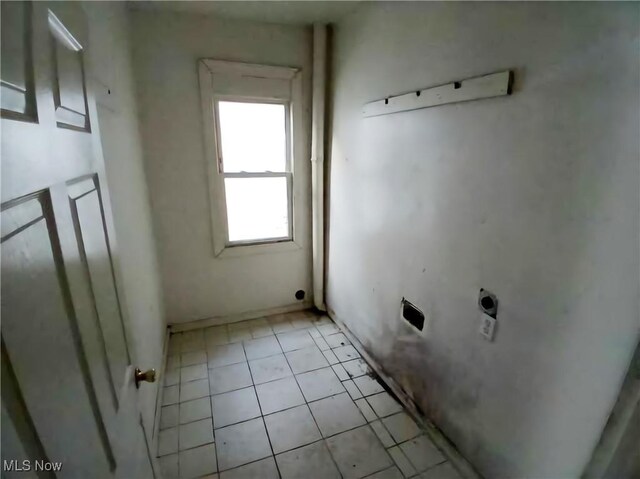 clothes washing area featuring light tile patterned floors and hookup for an electric dryer