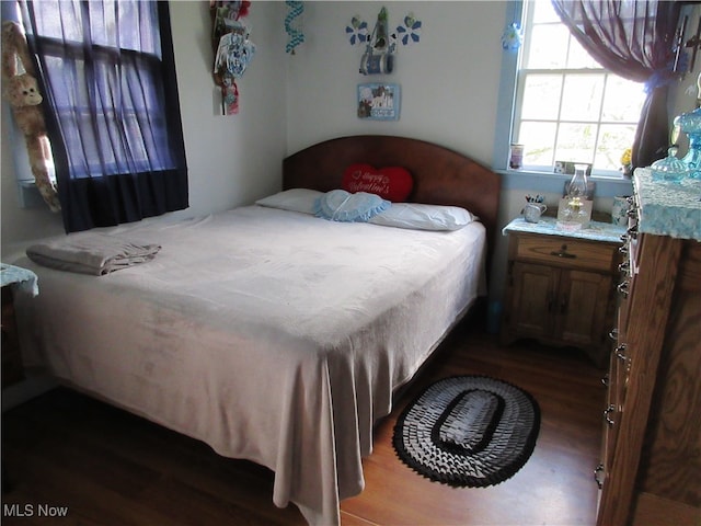 bedroom with dark wood-type flooring