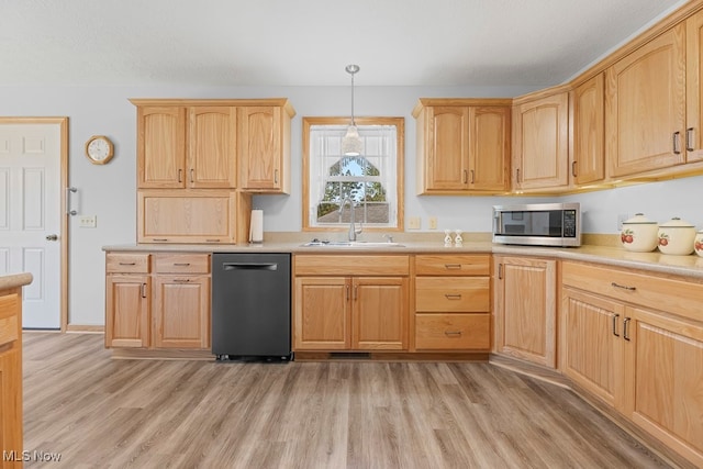 kitchen with light wood-type flooring, pendant lighting, stainless steel appliances, and sink