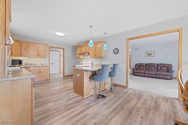 kitchen with hanging light fixtures, kitchen peninsula, a breakfast bar, electric range, and light wood-type flooring