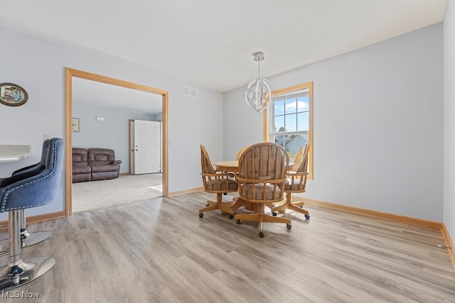 dining room featuring light hardwood / wood-style floors and a notable chandelier