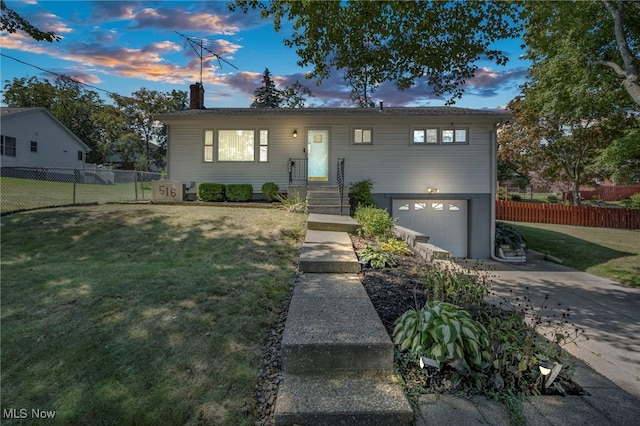 view of front of property with a garage and a yard