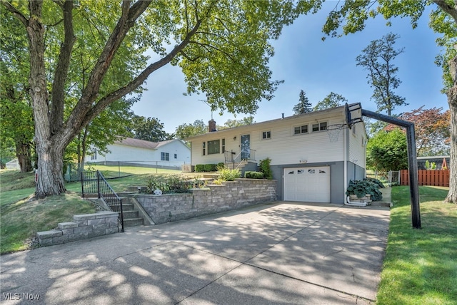 view of front of home with a garage and a front lawn