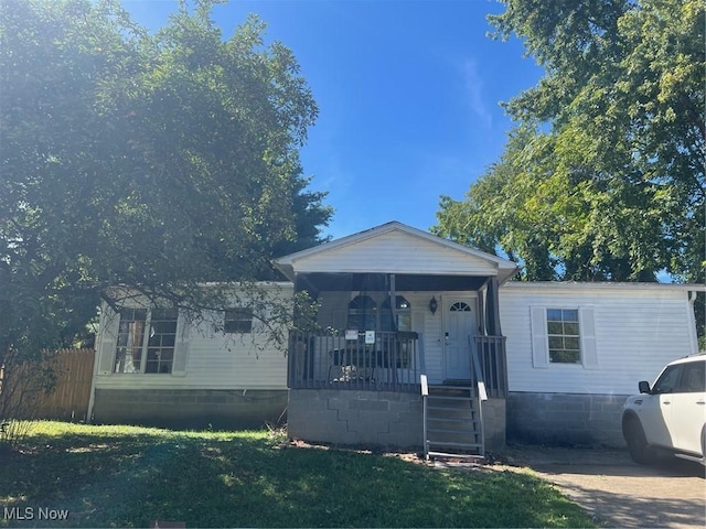 view of front of property with a porch, a front yard, and fence