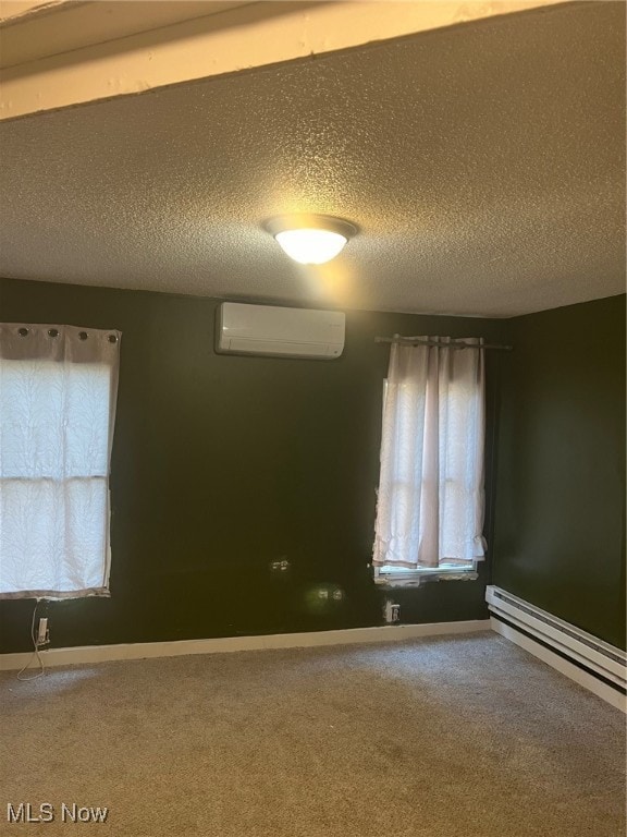 carpeted empty room with baseboard heating, a textured ceiling, and an AC wall unit