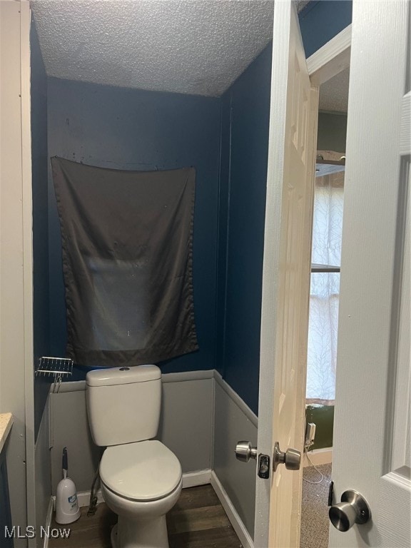 bathroom with toilet, hardwood / wood-style floors, and a textured ceiling