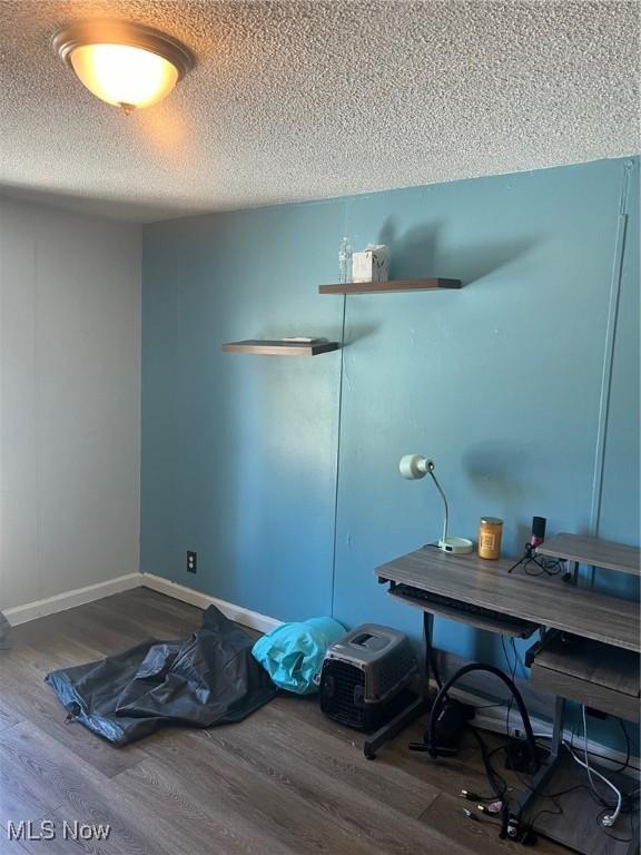 interior space featuring a textured ceiling and hardwood / wood-style floors