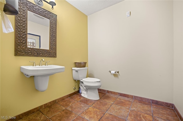 bathroom featuring a textured ceiling and toilet