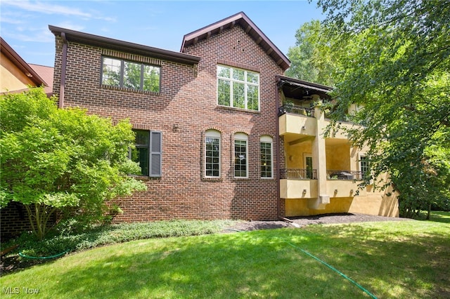 view of front of house featuring a balcony and a front lawn