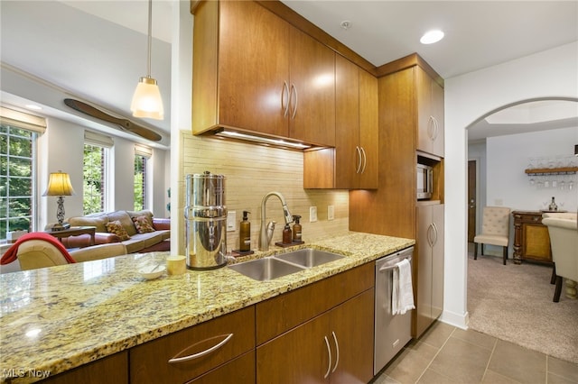 kitchen featuring stainless steel dishwasher, backsplash, light stone counters, and sink