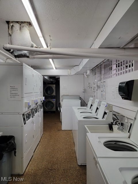 laundry area featuring washer and dryer, a textured ceiling, and stacked washer and clothes dryer