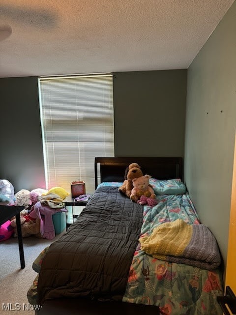 carpeted bedroom featuring a textured ceiling