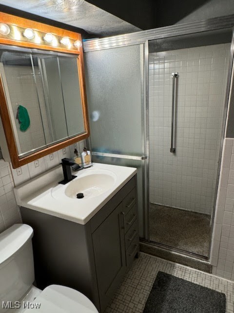 bathroom with vanity, toilet, and an enclosed shower