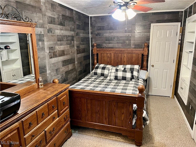 bedroom featuring a textured ceiling, light colored carpet, ceiling fan, and wooden walls