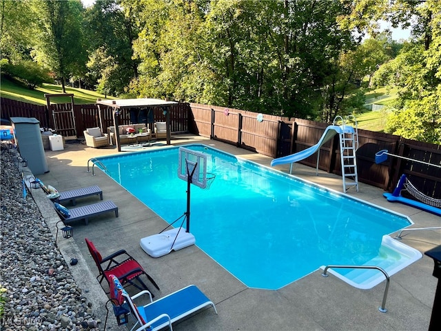 view of swimming pool with a water slide and a patio area