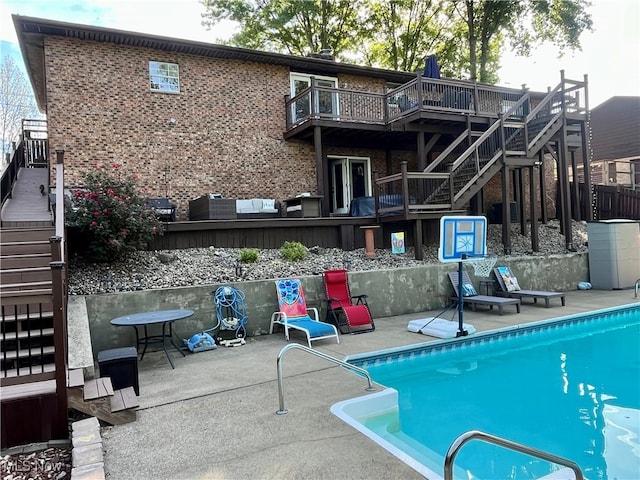 back of property with a pool side deck and a patio