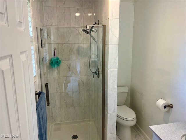 bathroom with vanity, toilet, and a tile shower