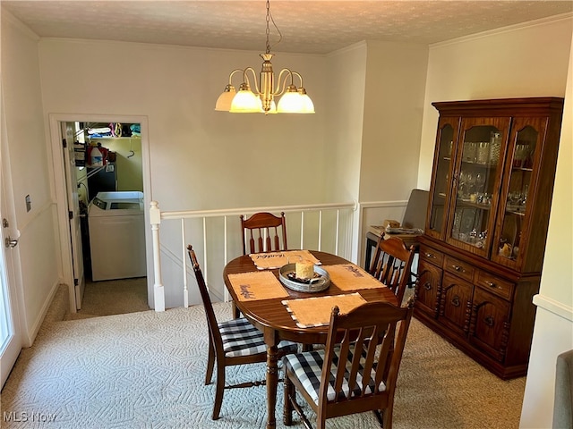 carpeted dining space featuring washer / dryer, a notable chandelier, and a textured ceiling