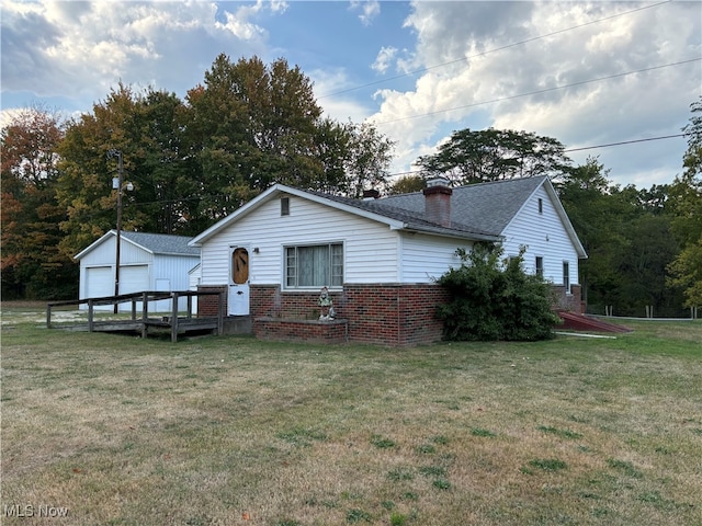 exterior space with a lawn, a garage, and an outdoor structure