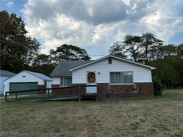 view of front facade with an outbuilding, a front yard, and a garage