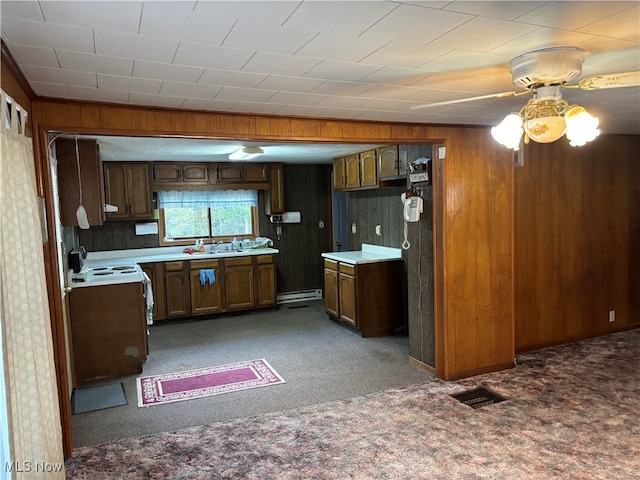 kitchen featuring wooden walls, baseboard heating, white electric range oven, ceiling fan, and dark colored carpet