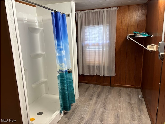 bathroom featuring wood walls, a shower with curtain, and hardwood / wood-style flooring