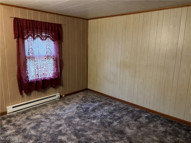 carpeted empty room with ornamental molding, baseboard heating, and wooden walls