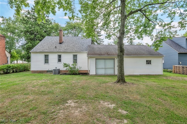 rear view of house with cooling unit and a yard