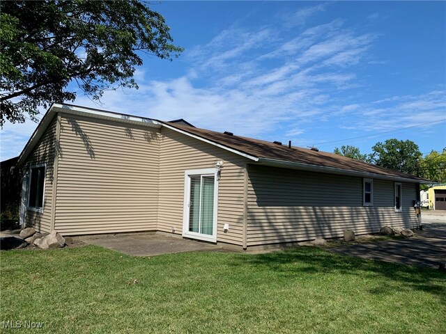 back of property featuring a yard and a patio